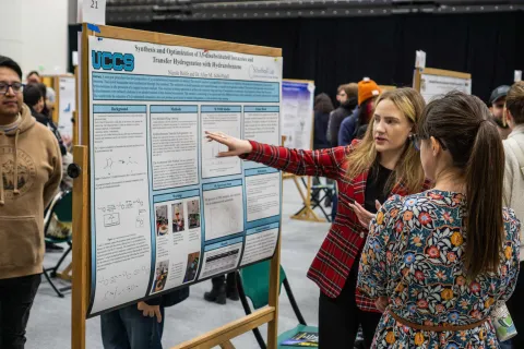 student presenting research poster