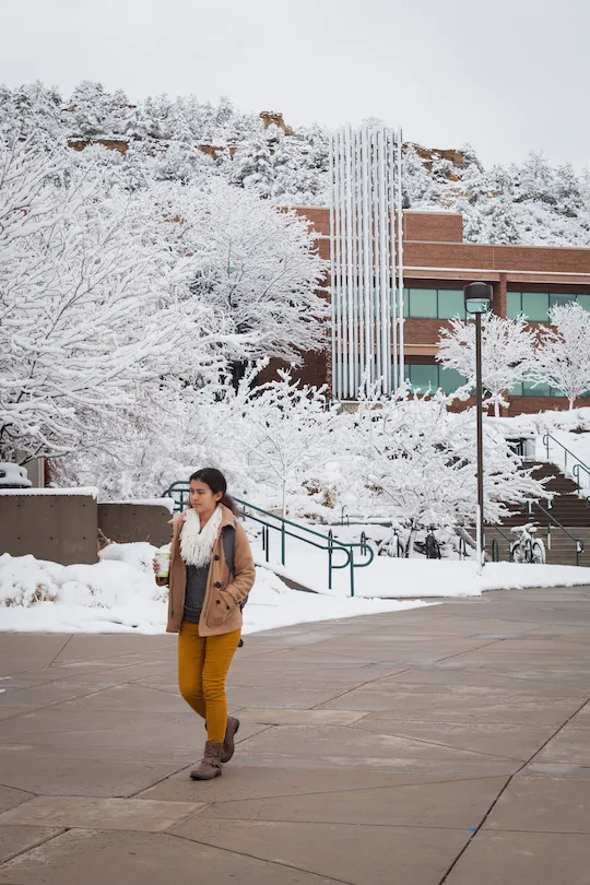 Person walking around the UCCS campus on a snowy day.